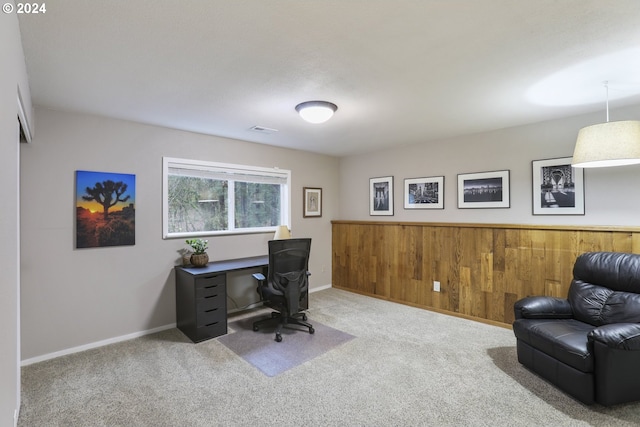 carpeted office featuring wood walls