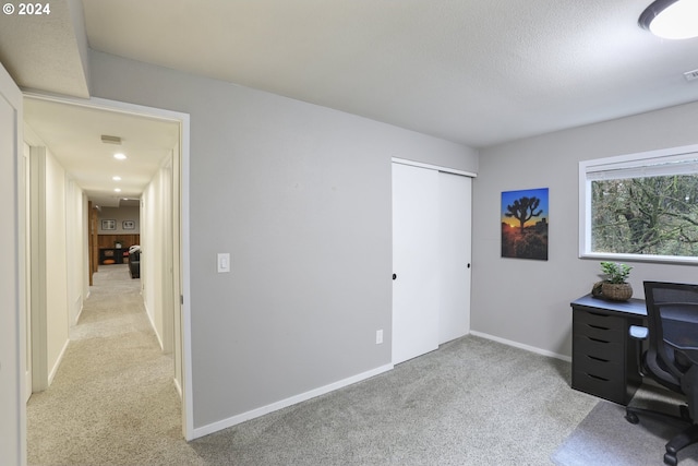 carpeted office featuring a textured ceiling