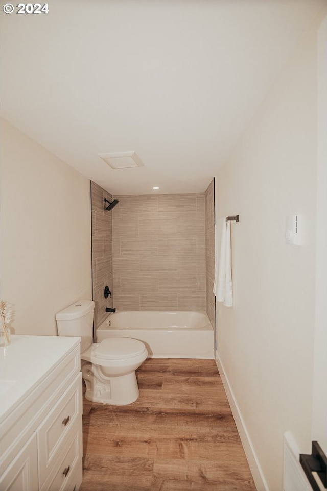 full bathroom featuring tiled shower / bath, vanity, toilet, and hardwood / wood-style flooring