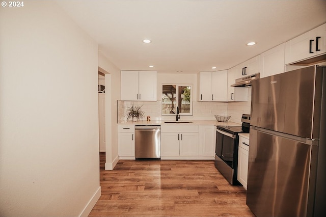 kitchen featuring stainless steel appliances, white cabinetry, light hardwood / wood-style floors, and sink