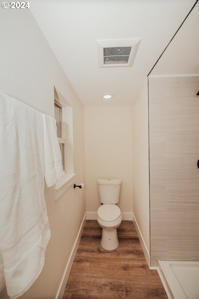 bathroom featuring a shower, toilet, and hardwood / wood-style flooring