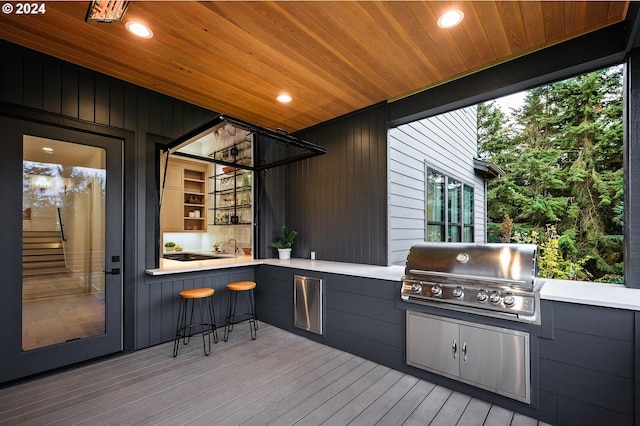 wooden deck with grilling area and exterior kitchen