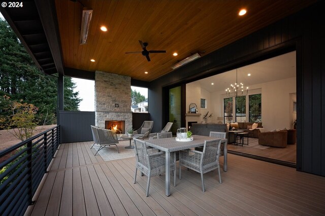 wooden terrace with an outdoor living space with a fireplace and ceiling fan