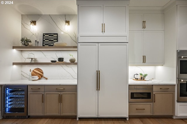 bar with beverage cooler, wood-type flooring, paneled built in fridge, and tasteful backsplash