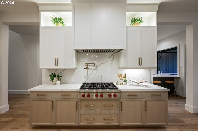 kitchen with stainless steel gas cooktop, light brown cabinets, dark hardwood / wood-style floors, and tasteful backsplash