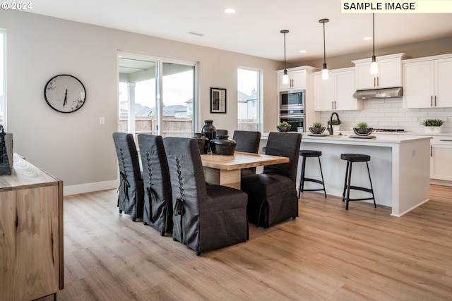 dining room with sink and light hardwood / wood-style flooring