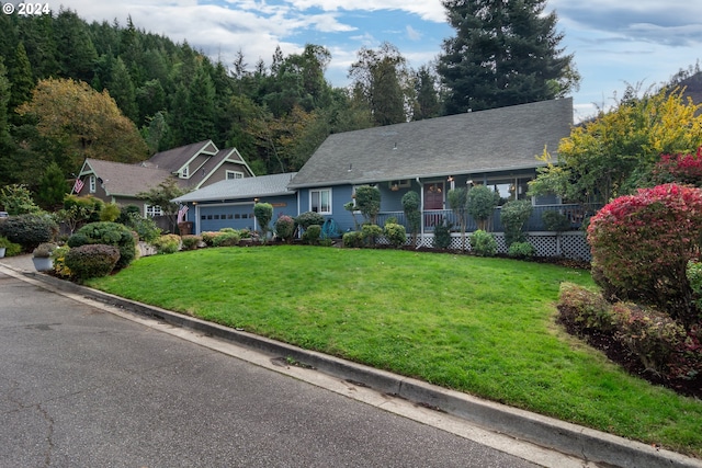 view of front facade with a porch, a front lawn, and a garage