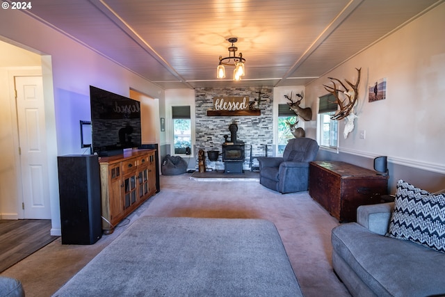 living room with a wood stove, light hardwood / wood-style flooring, and wooden ceiling