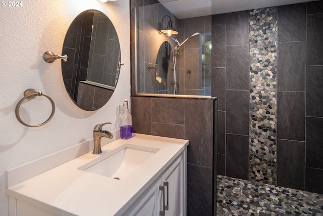 bathroom featuring a tile shower and vanity