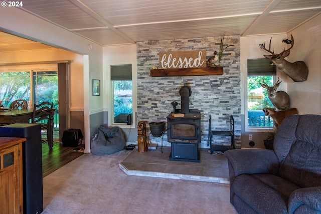 living room featuring wood ceiling, carpet flooring, and a wood stove