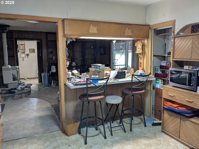 kitchen with a kitchen bar and wood walls