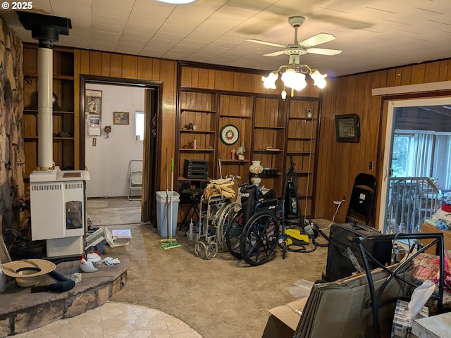 interior space with light carpet, ceiling fan, and wood walls