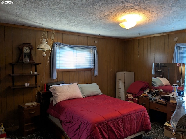 bedroom with a textured ceiling and wood walls