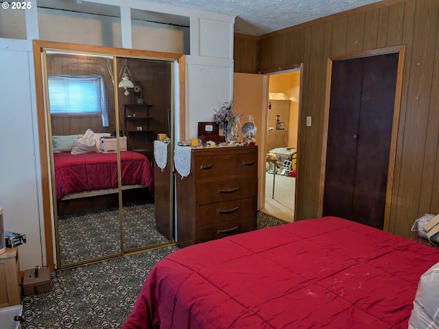 bedroom with wooden walls, a closet, and a textured ceiling