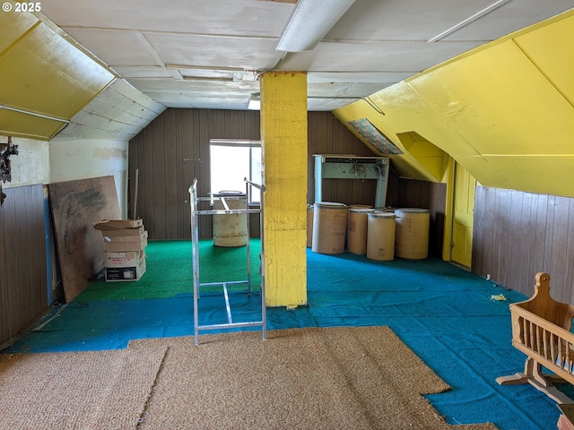 additional living space with lofted ceiling, wooden walls, and dark colored carpet