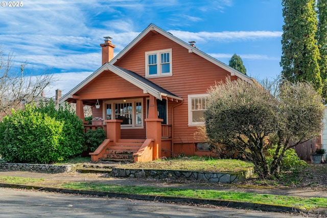 view of front of house with covered porch and a chimney