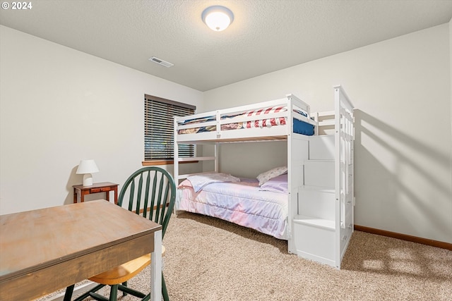 carpeted bedroom featuring a textured ceiling