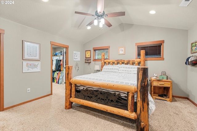 carpeted bedroom featuring lofted ceiling, a spacious closet, ceiling fan, and a closet