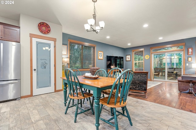 dining space with a chandelier and light hardwood / wood-style floors