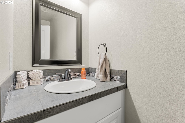 bathroom featuring vanity and backsplash