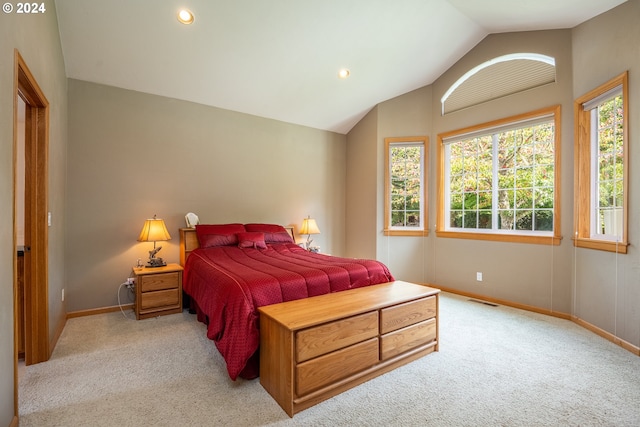 bedroom with vaulted ceiling and light colored carpet