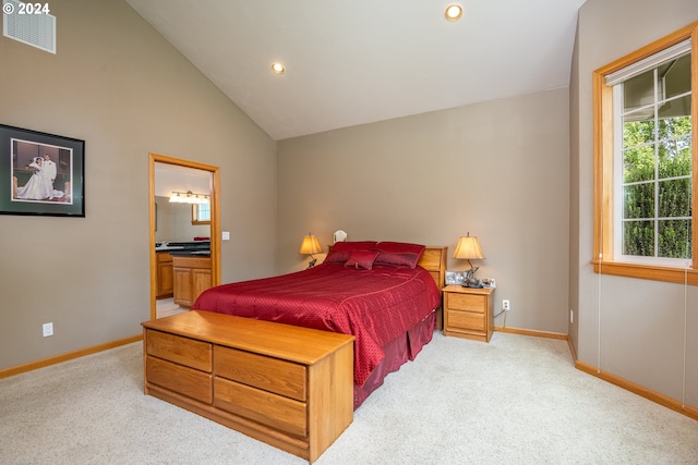 bedroom with light colored carpet, ensuite bath, and high vaulted ceiling