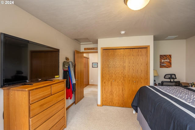 bedroom featuring a closet, light colored carpet, and a textured ceiling