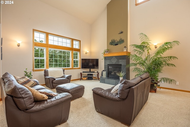 living room featuring carpet floors, a tiled fireplace, high vaulted ceiling, and a wealth of natural light