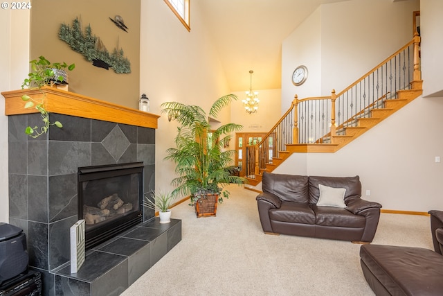 carpeted living room with a tiled fireplace, a chandelier, and a high ceiling