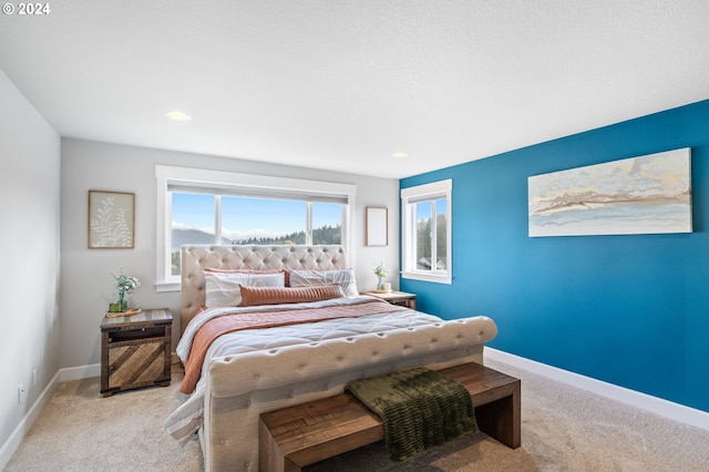 bedroom with light carpet and multiple windows