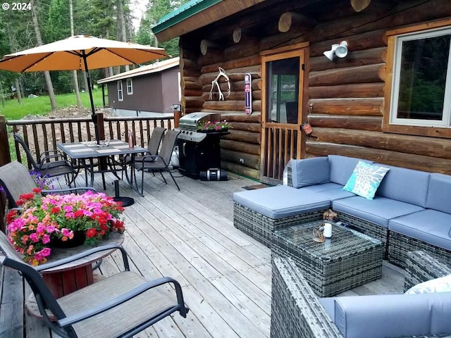 wooden terrace with an outdoor hangout area and area for grilling