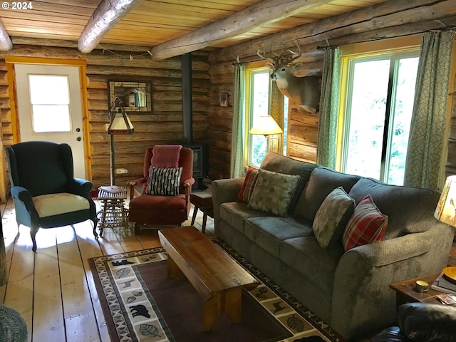 60020 Wilderness Rd, Joseph, OR 97846 - sitting room featuring a wood stove, wood-type flooring, plenty of natural light, wood ceiling with exposed beams, and log walls