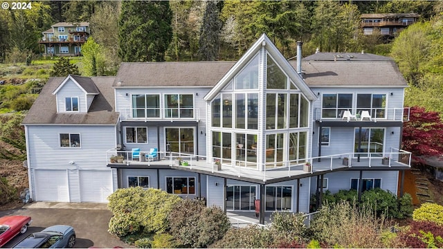 rear view of property featuring driveway and an attached garage