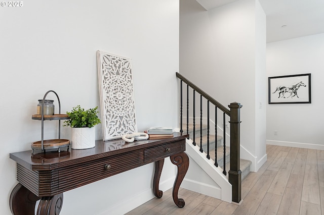 stairway featuring baseboards and wood finished floors