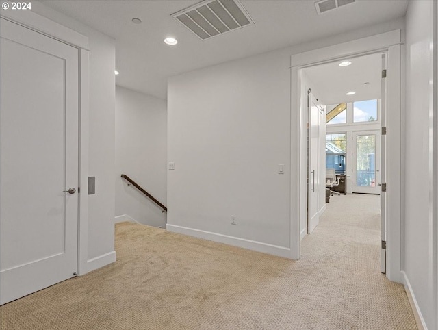 interior space with carpet floors, recessed lighting, visible vents, and an upstairs landing