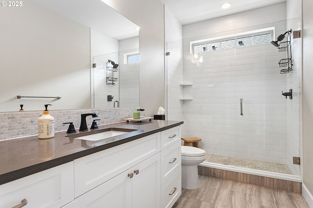 full bath featuring decorative backsplash, vanity, a shower stall, and toilet