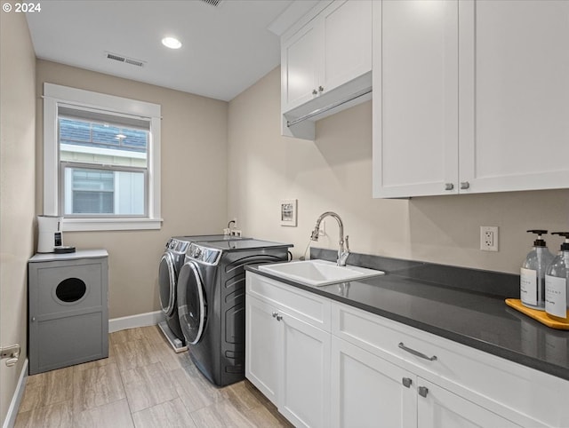 laundry area with separate washer and dryer, a sink, visible vents, baseboards, and cabinet space