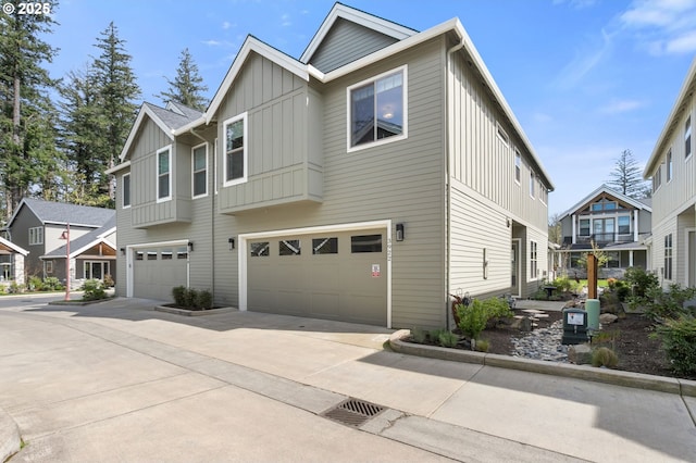 view of front of property featuring an attached garage, board and batten siding, driveway, and a residential view