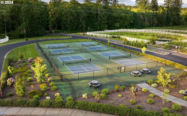 view of sport court featuring a view of trees and fence