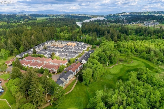 aerial view with golf course view, a wooded view, and a residential view