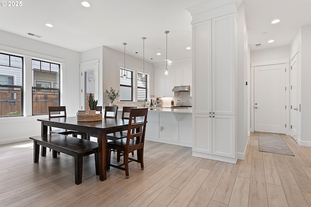 dining room with light wood finished floors, baseboards, visible vents, and recessed lighting