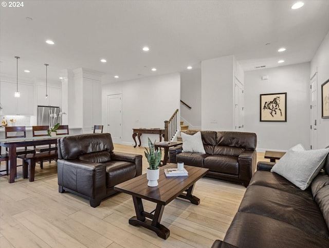 living area with light wood-type flooring, baseboards, stairway, and recessed lighting