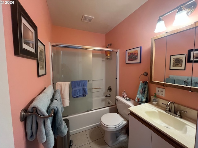 full bathroom with vanity, bath / shower combo with glass door, toilet, and tile patterned floors