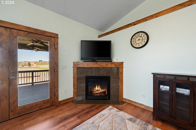 living room featuring a fireplace, vaulted ceiling, and hardwood / wood-style floors