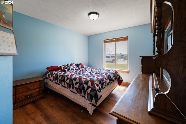 bedroom with dark wood-type flooring and a textured ceiling