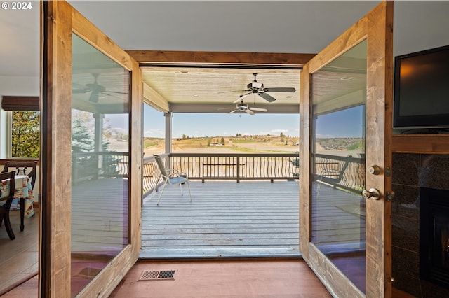 entryway with a tile fireplace, ceiling fan, and hardwood / wood-style floors