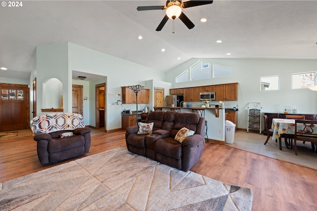 living room with high vaulted ceiling, light wood-type flooring, and ceiling fan