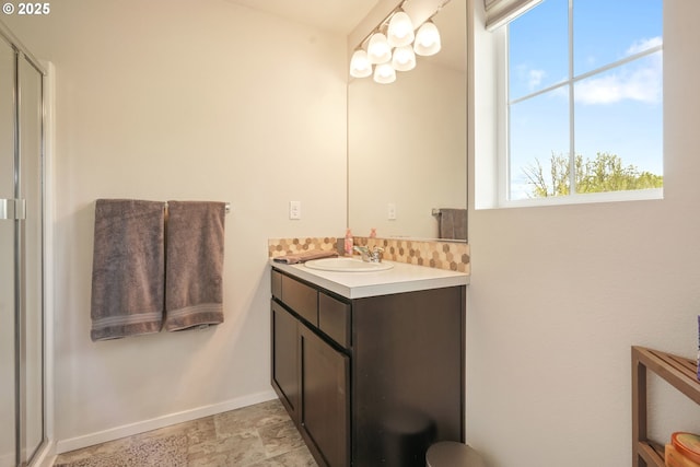 full bathroom featuring baseboards, vanity, and a shower with door