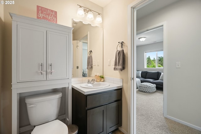 bathroom with vanity, toilet, and connected bathroom