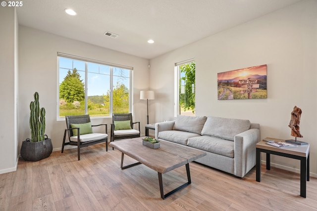 living area with light wood-style floors, baseboards, and recessed lighting